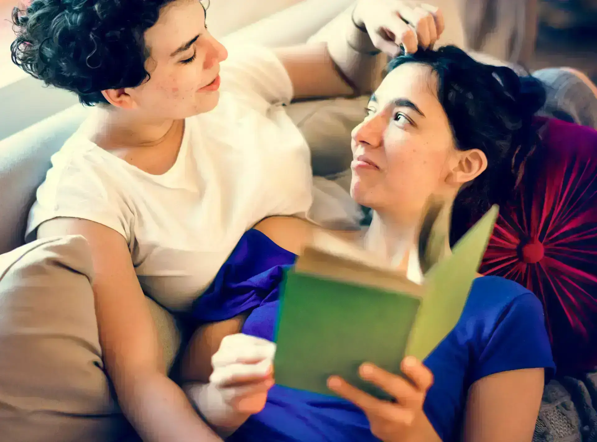 Lesbian couple practice a caring behavior: reading a book together to strengthen quality time and affection.